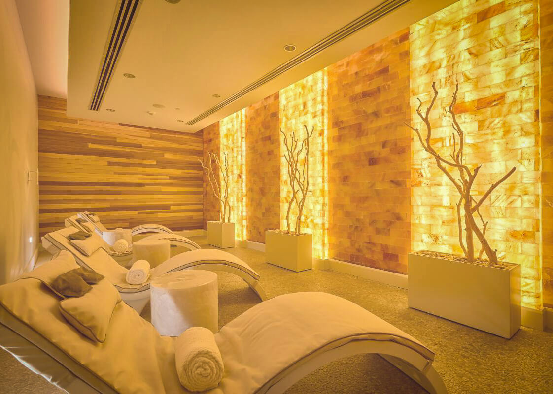 Halotherapy salt room with backlit Himalayan salt walls and loungers