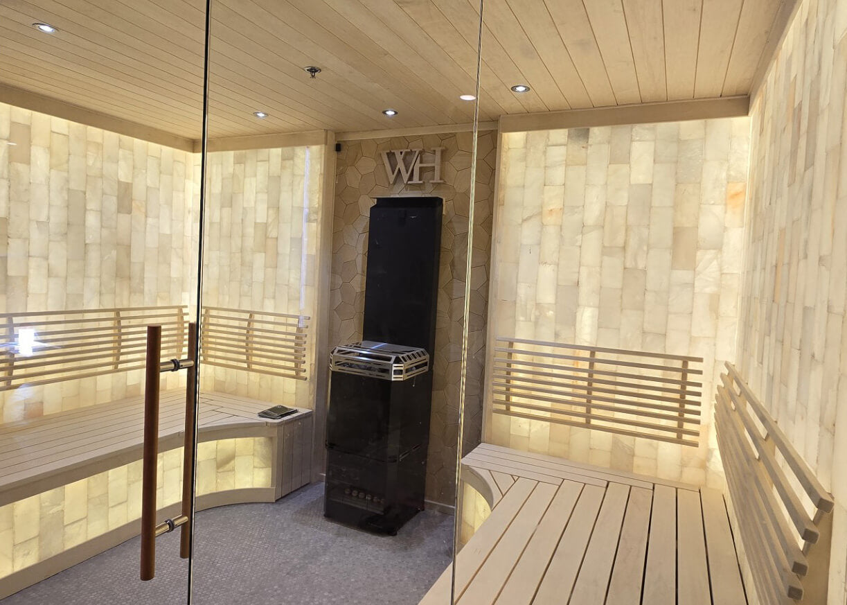 Cedar sauna interior with glass door, tiered benching and stove